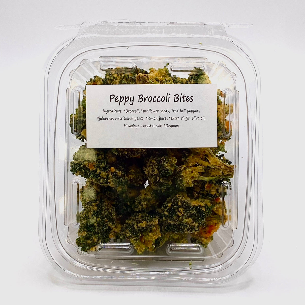 Healing Home Foods Peppy Broccoli Bites is a clear plastic container of seasoned organic broccoli florets with sunflower seeds and jalapeño—a delicious, sulforaphane-rich snack.